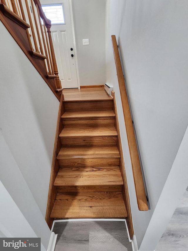 stairway featuring hardwood / wood-style floors and baseboard heating