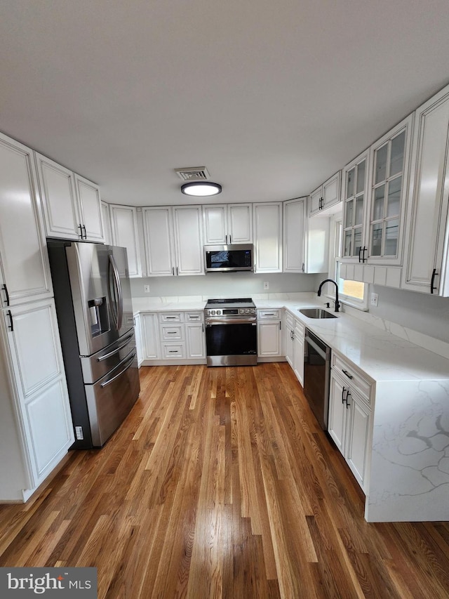 kitchen with white cabinets, dark hardwood / wood-style floors, sink, and stainless steel appliances