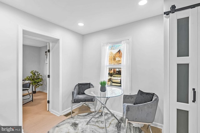 sitting room featuring hardwood / wood-style flooring and a barn door