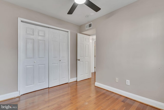 unfurnished bedroom featuring a closet, light hardwood / wood-style flooring, and ceiling fan