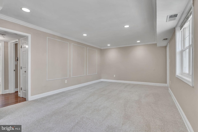 carpeted spare room featuring crown molding