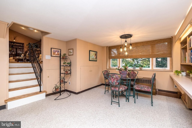 carpeted dining room with an inviting chandelier and a baseboard heating unit