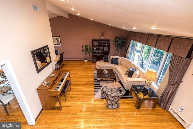 living room featuring lofted ceiling, light wood-type flooring, and a baseboard heating unit