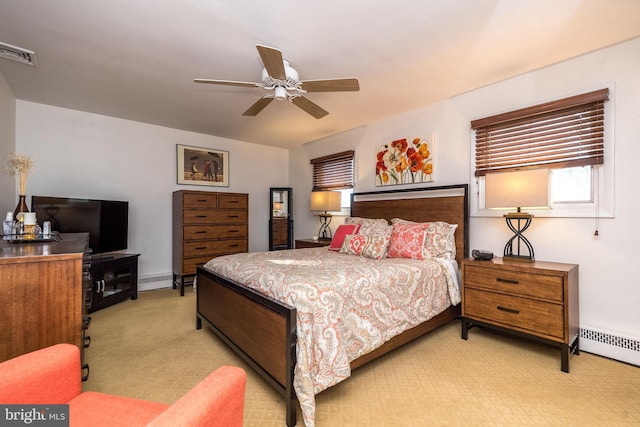 carpeted bedroom featuring ceiling fan and a baseboard heating unit