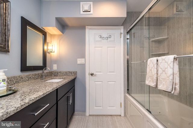 bathroom with vanity and enclosed tub / shower combo