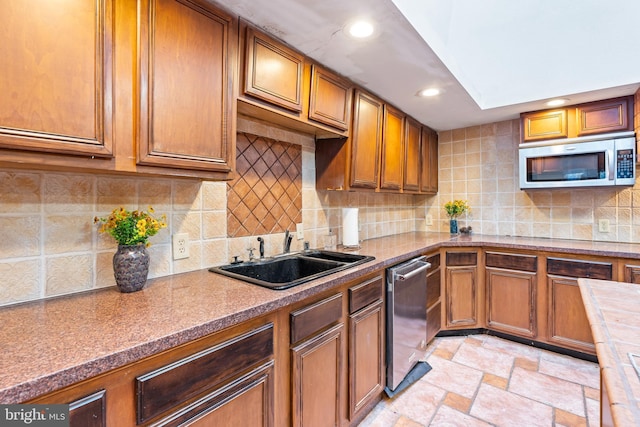 kitchen with appliances with stainless steel finishes, tasteful backsplash, and sink