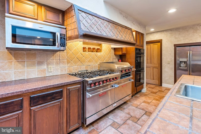 kitchen with premium range hood, decorative backsplash, and stainless steel appliances