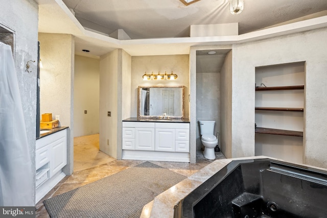 bathroom with vanity, toilet, and a textured ceiling