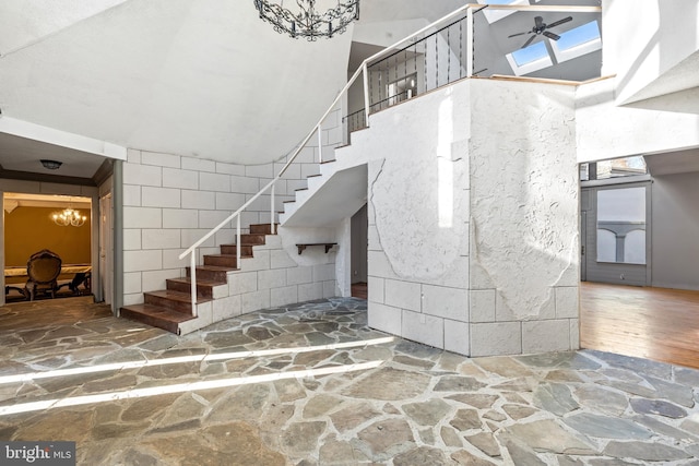 staircase featuring hardwood / wood-style floors and ceiling fan with notable chandelier