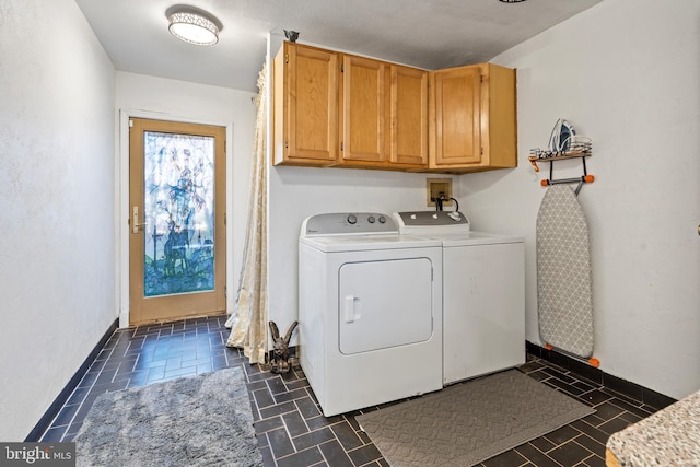 clothes washing area featuring cabinets and independent washer and dryer