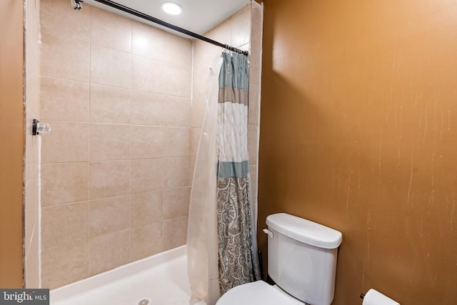 bathroom with curtained shower and toilet