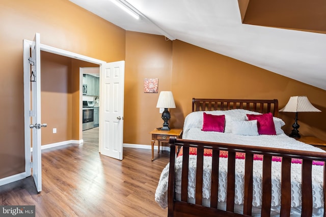 bedroom with lofted ceiling and hardwood / wood-style flooring