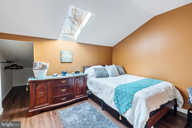 bedroom featuring vaulted ceiling with skylight and wood-type flooring