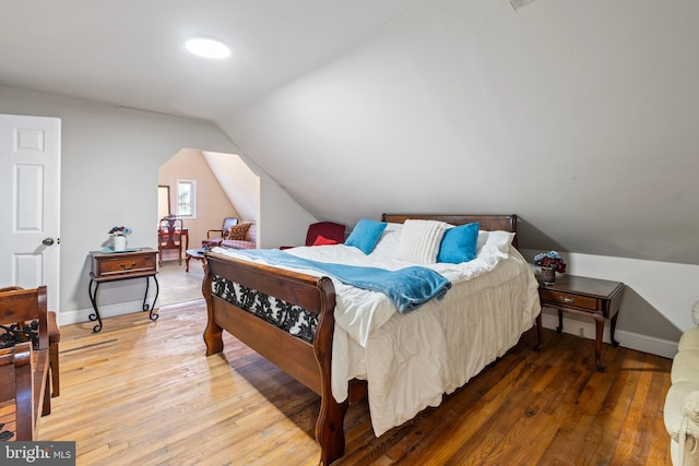 bedroom featuring hardwood / wood-style floors and lofted ceiling