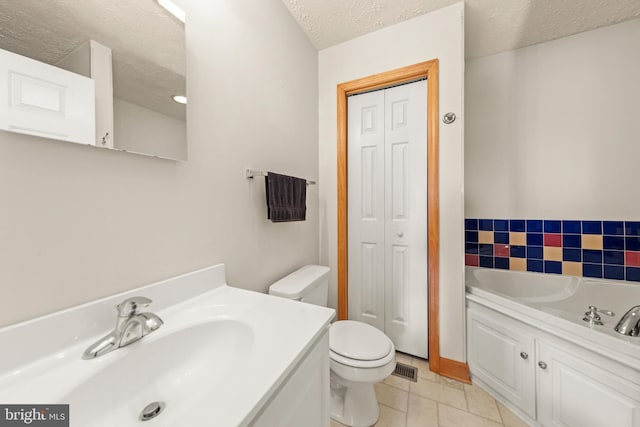 bathroom with tile patterned flooring, vanity, a textured ceiling, and toilet