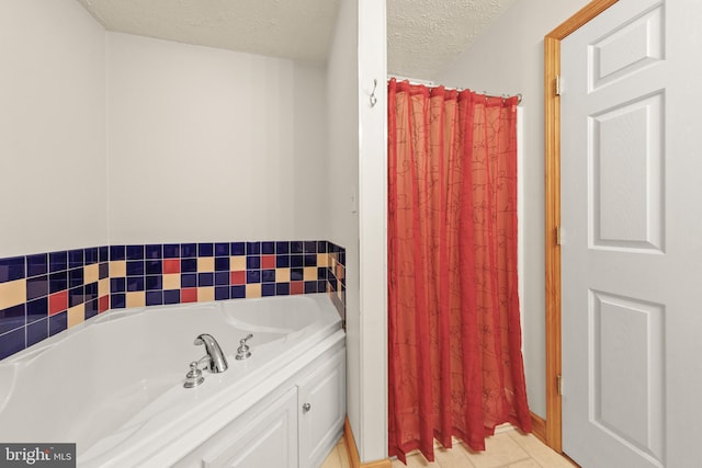 bathroom with a textured ceiling and a tub