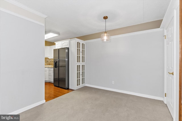 empty room with light colored carpet and crown molding