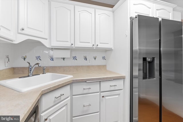 kitchen with decorative backsplash, stainless steel fridge, sink, and white cabinets