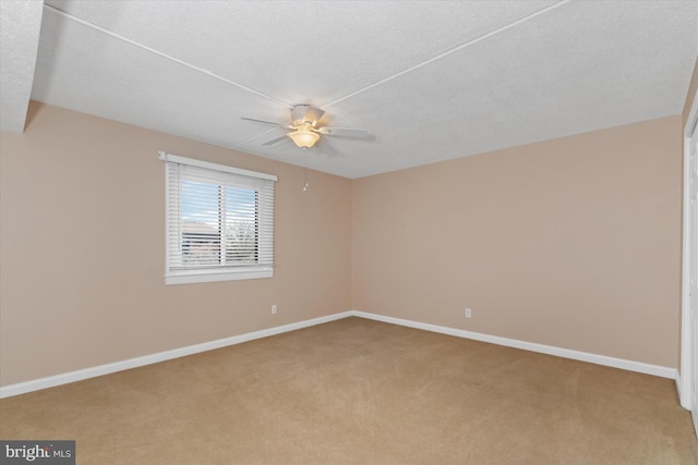 carpeted empty room with ceiling fan and a textured ceiling