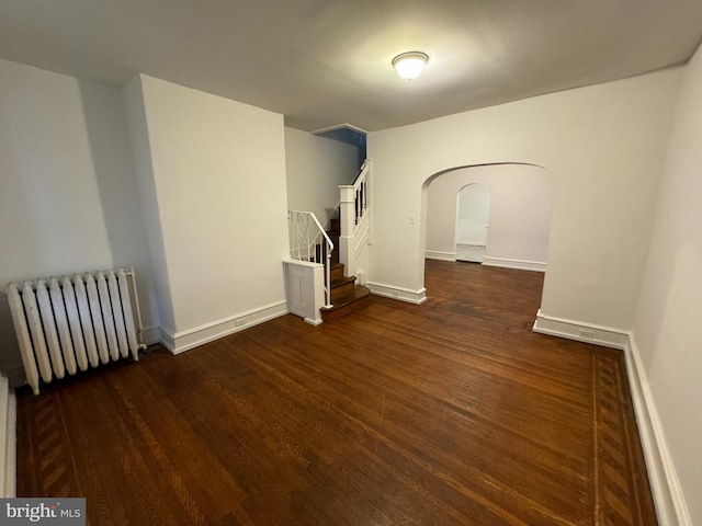 empty room with radiator and dark hardwood / wood-style flooring