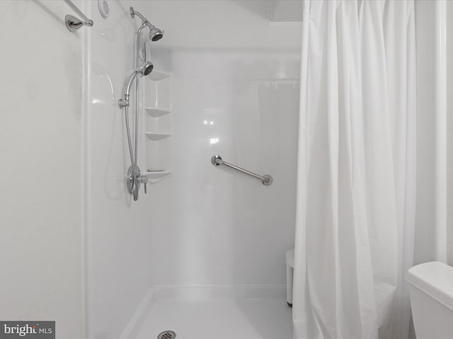 bathroom featuring curtained shower and toilet