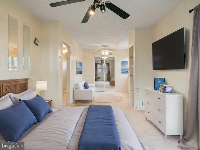 carpeted bedroom featuring ceiling fan and a textured ceiling