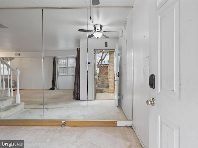 carpeted foyer with ceiling fan