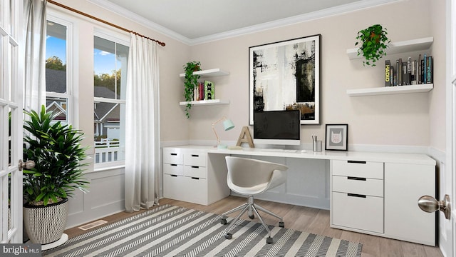 office area with ornamental molding, built in desk, light hardwood / wood-style floors, and a healthy amount of sunlight