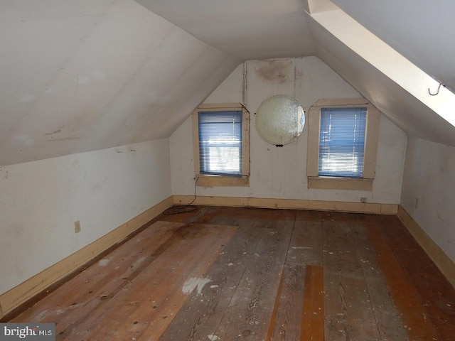 bonus room with dark hardwood / wood-style flooring and vaulted ceiling