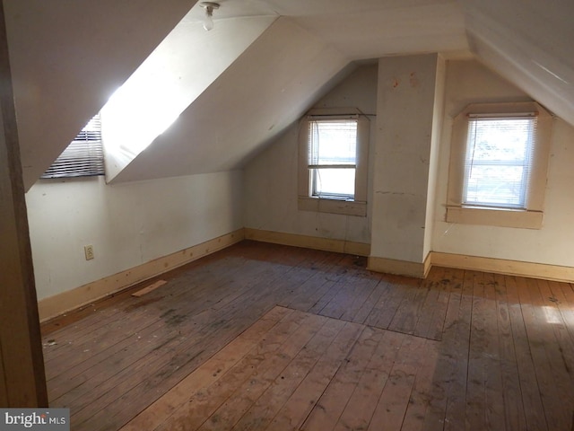 additional living space featuring hardwood / wood-style floors and lofted ceiling