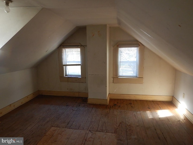 bonus room featuring vaulted ceiling, plenty of natural light, and dark wood-type flooring