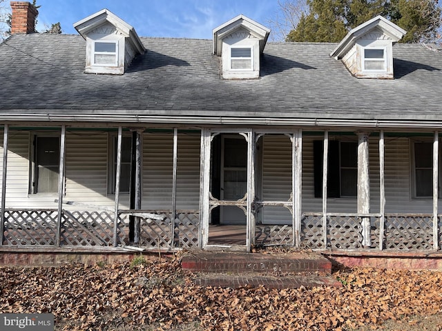 cape cod house featuring covered porch