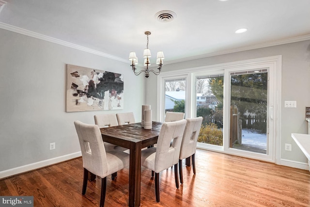 dining space with a chandelier, wood-type flooring, and crown molding