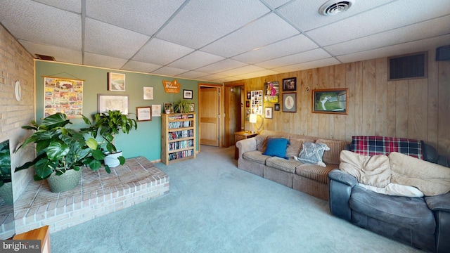 living room with carpet floors and wooden walls