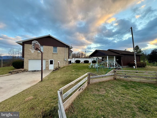 property exterior at dusk featuring a lawn and a garage