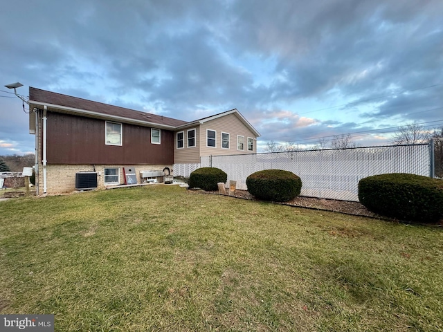 back of property featuring a yard and central AC