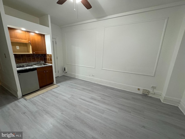 kitchen featuring ceiling fan, sink, stainless steel dishwasher, decorative backsplash, and light wood-type flooring