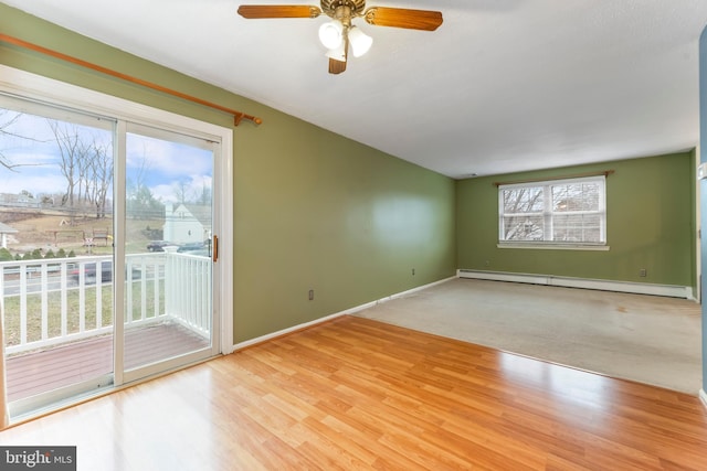 spare room featuring a baseboard radiator, light hardwood / wood-style flooring, and plenty of natural light