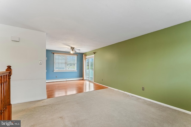 carpeted empty room with ceiling fan and a baseboard heating unit