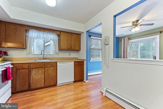 kitchen with light wood-type flooring, white appliances, a baseboard heating unit, and sink