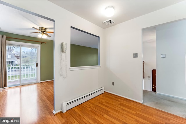 spare room featuring hardwood / wood-style floors, ceiling fan, and baseboard heating