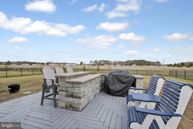 deck with exterior bar, a rural view, and grilling area