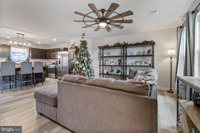 living room with light hardwood / wood-style flooring and ceiling fan