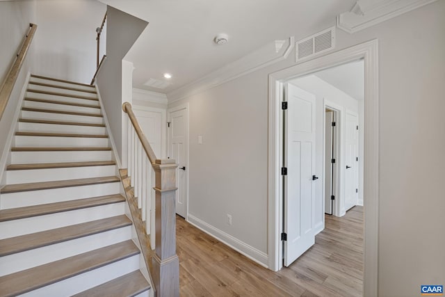 stairway featuring hardwood / wood-style flooring and ornamental molding