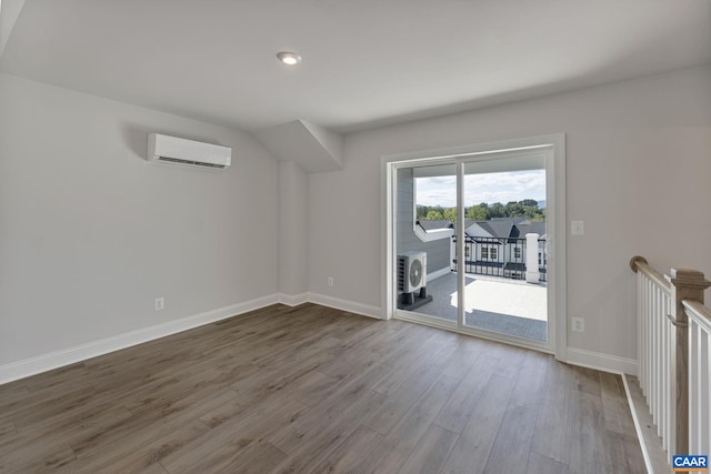 unfurnished living room with hardwood / wood-style flooring and a wall mounted AC