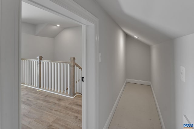 corridor featuring light hardwood / wood-style flooring and lofted ceiling