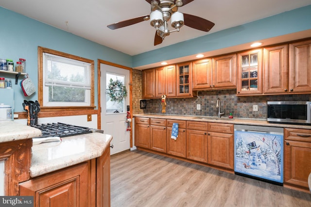 kitchen featuring ceiling fan, sink, stainless steel appliances, tasteful backsplash, and light hardwood / wood-style floors