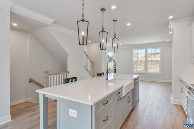 kitchen with a kitchen breakfast bar, light wood-type flooring, pendant lighting, dishwasher, and an island with sink