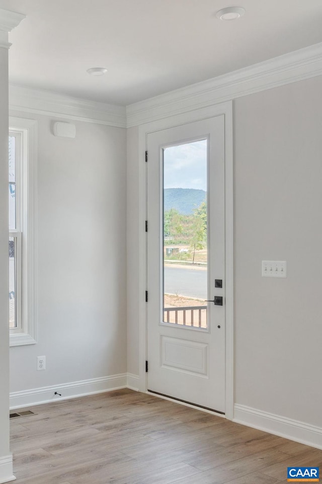 doorway to outside featuring light wood-type flooring and ornamental molding