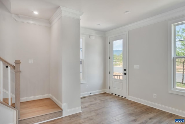 entryway with light hardwood / wood-style flooring, plenty of natural light, and crown molding